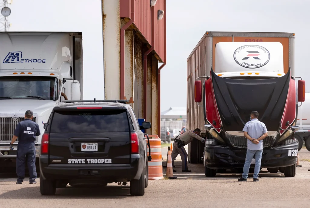 State trooper inspecting large truck at checkpoint