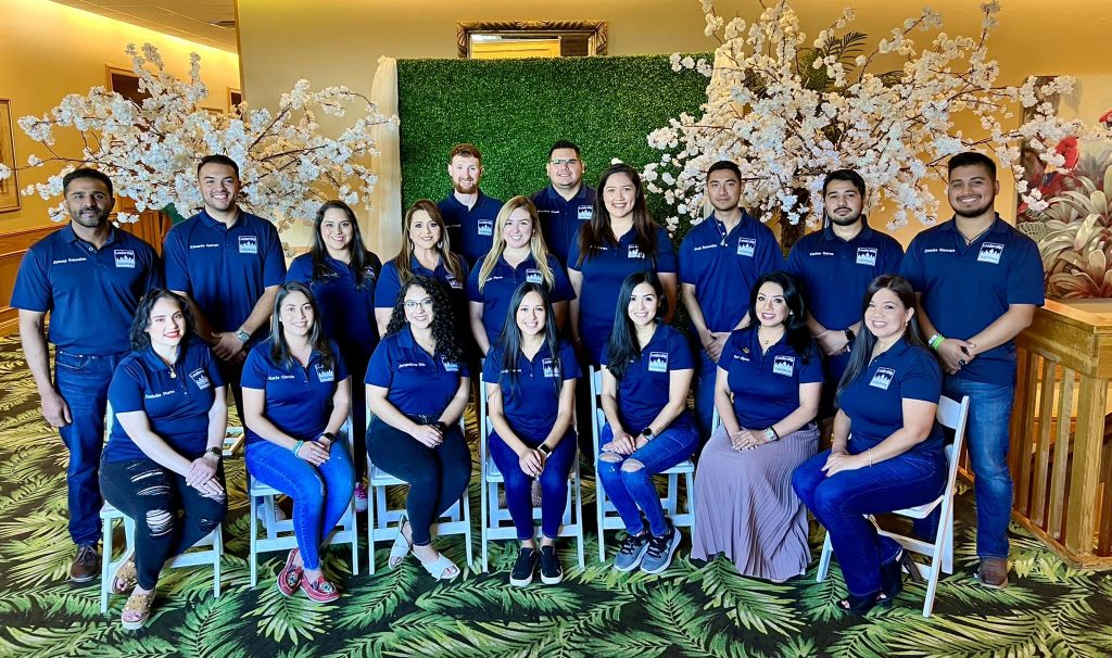Group of smiling adults in matching blue shirts