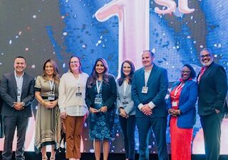 Group of conference speakers standing on stage