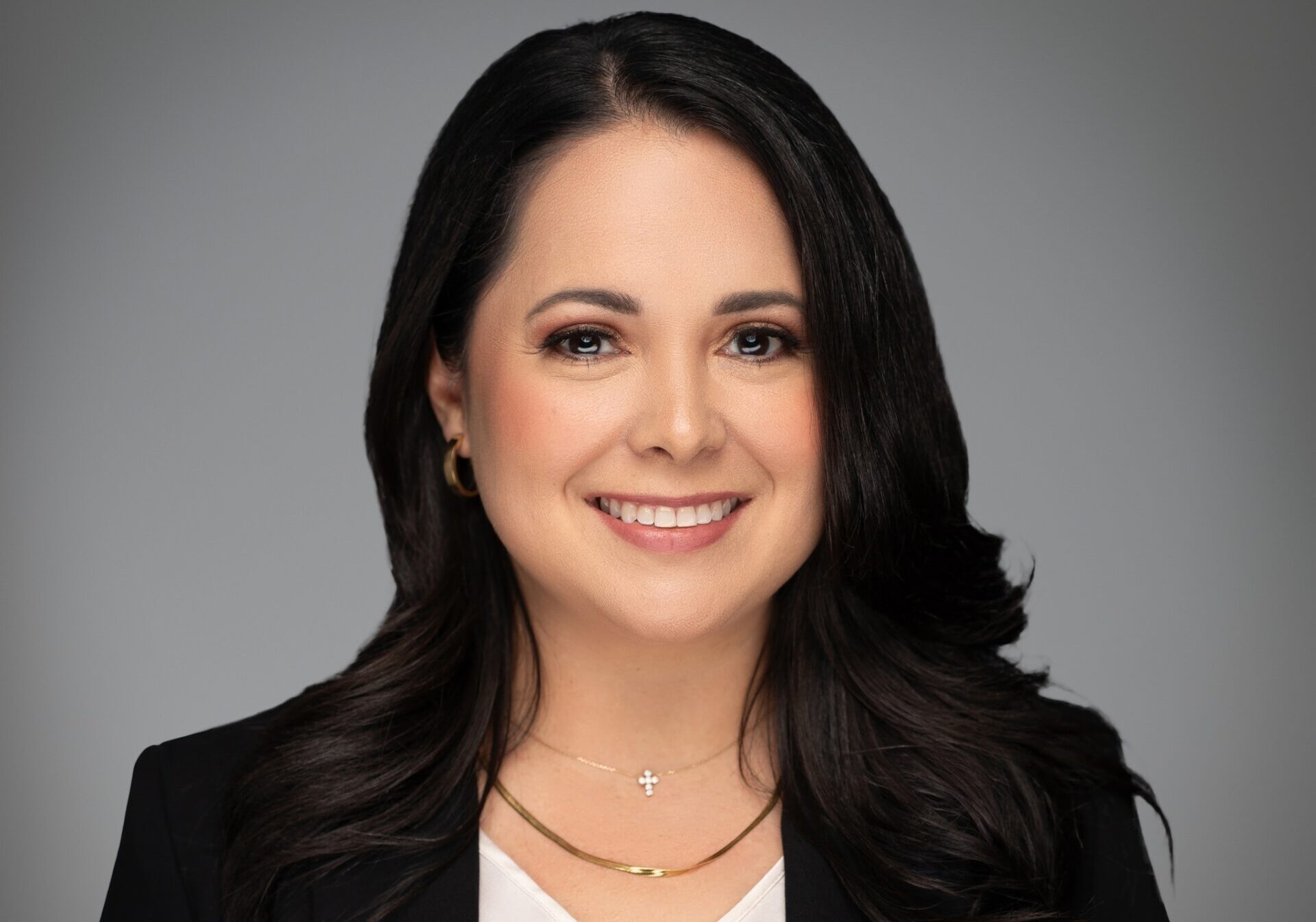 Professional headshot: smiling person with dark hair