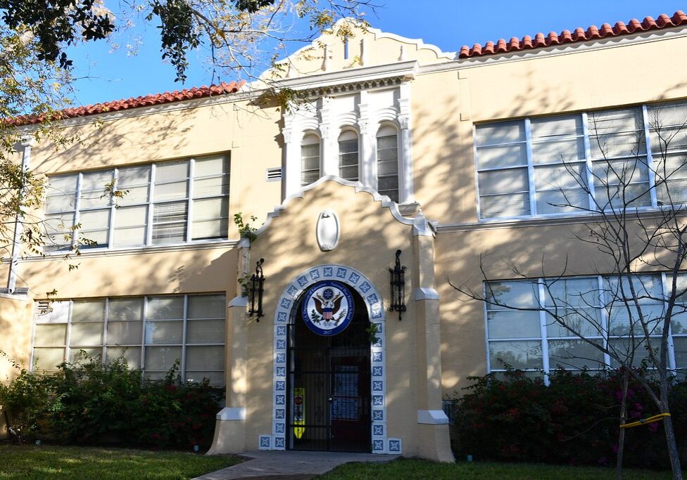 Stucco building with arched tiled entrance and seal