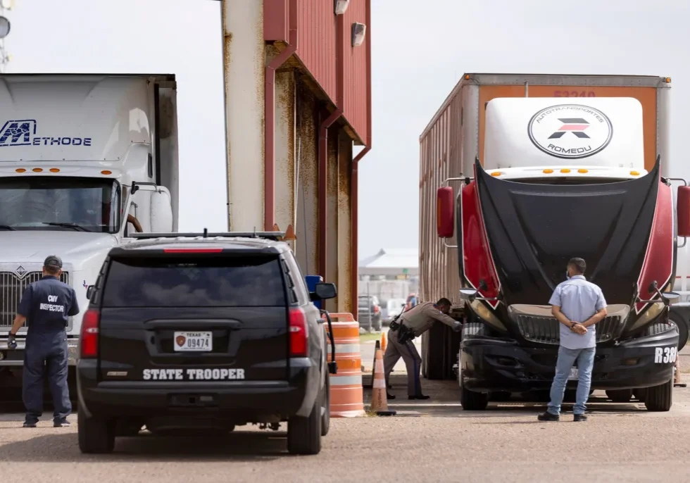 State trooper inspecting large truck at checkpoint
