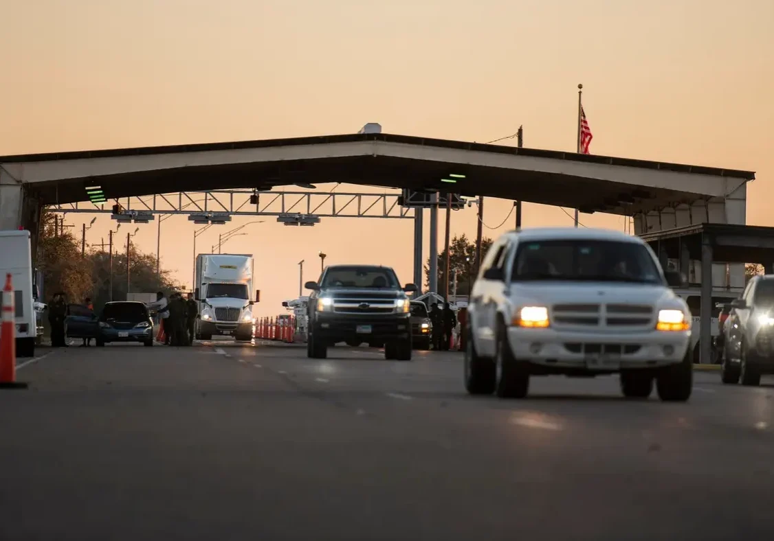 Cars approaching border checkpoint at dusk