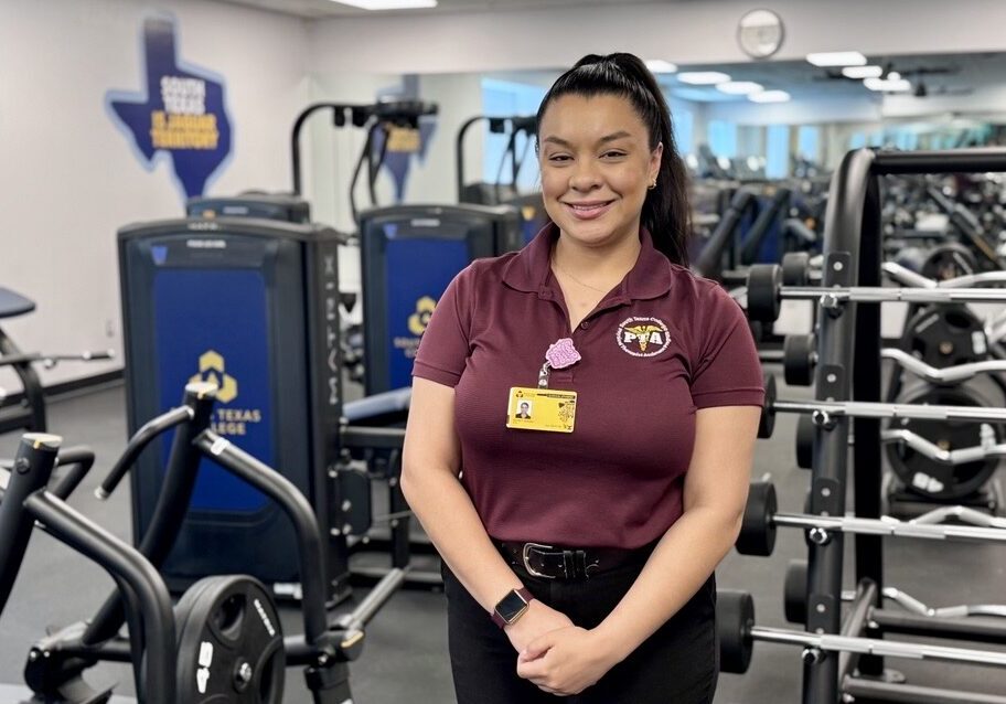 Woman smiling in gym wearing maroon polo