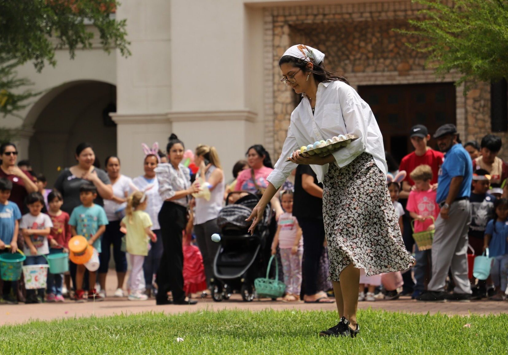 Woman picking egg at community Easter hunt