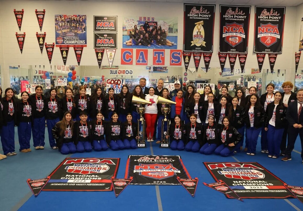 Cheerleading team posing with banners and trophies