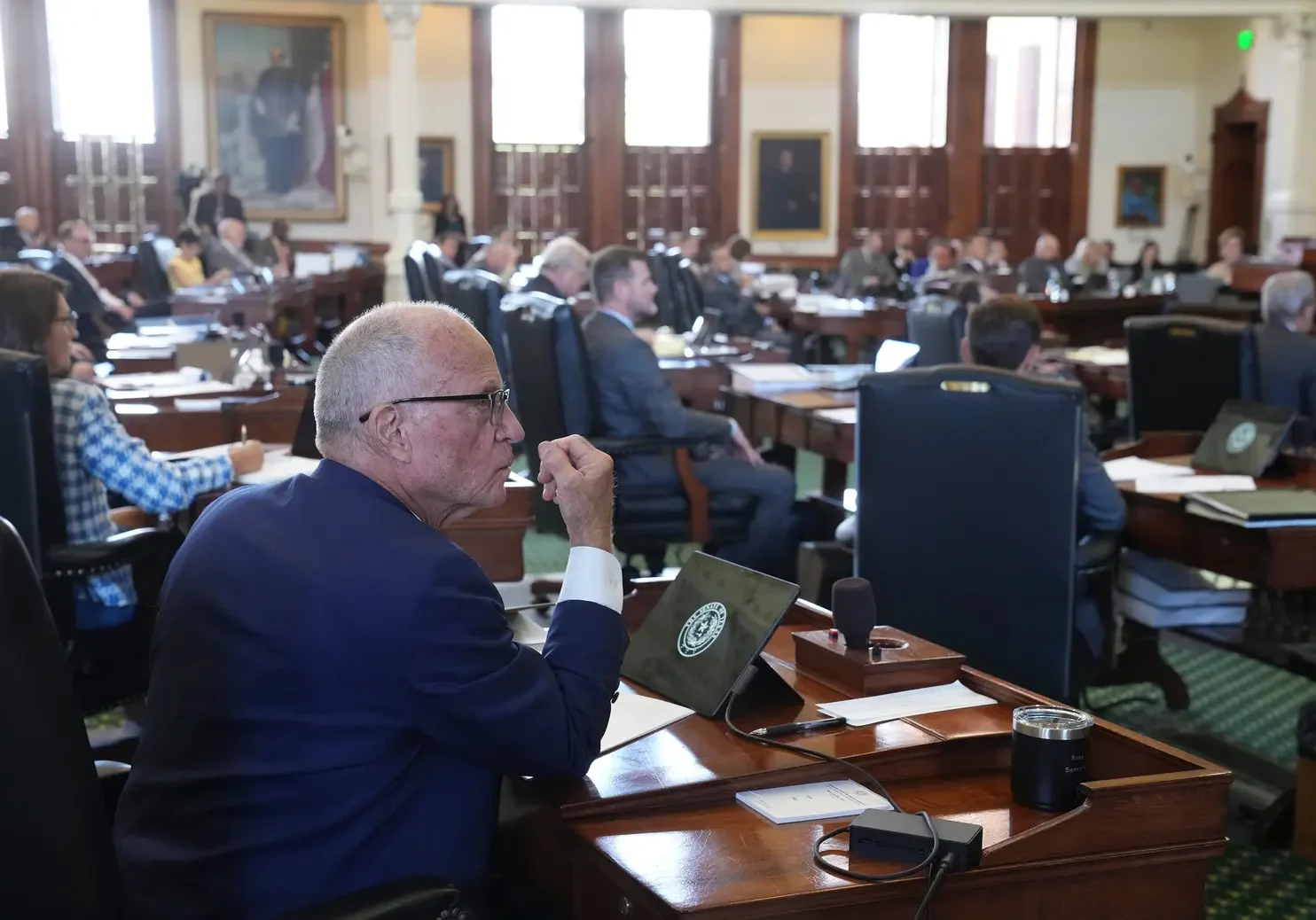 Lawmakers seated in legislative chamber during session
