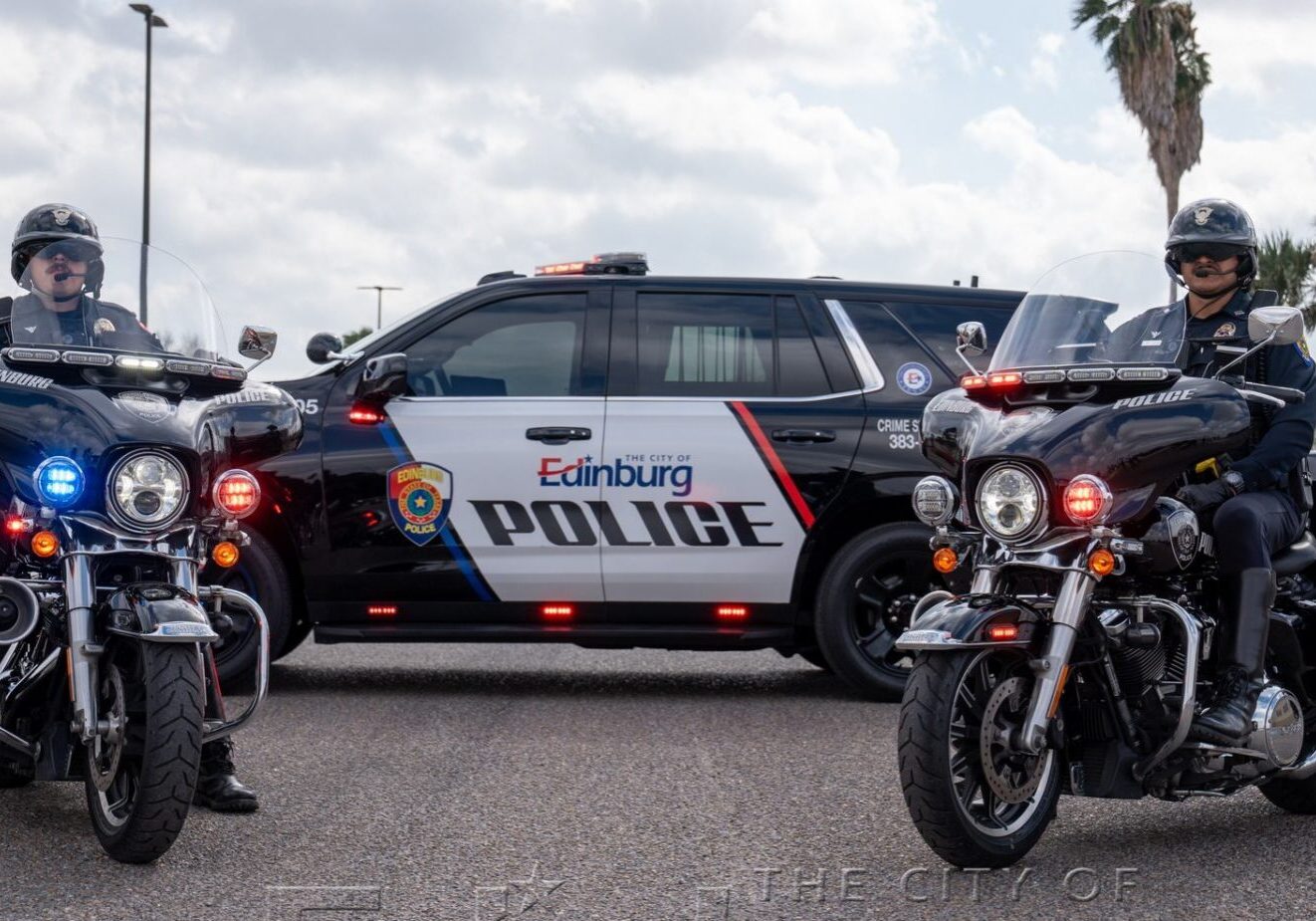 Two motorcycle officers beside Edinburg police SUV