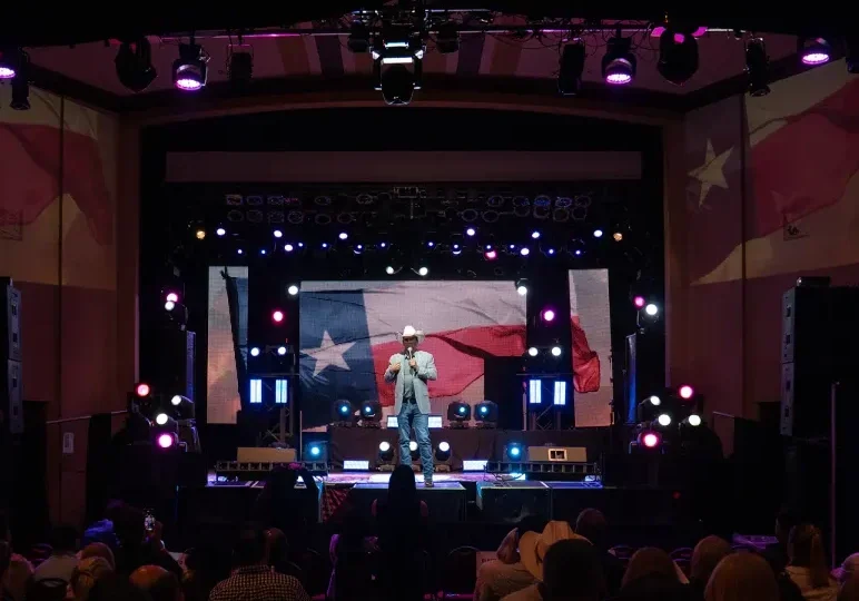 Performer on stage with large American flag backdrop