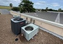 Two rooftop air conditioning condenser units on gravel
