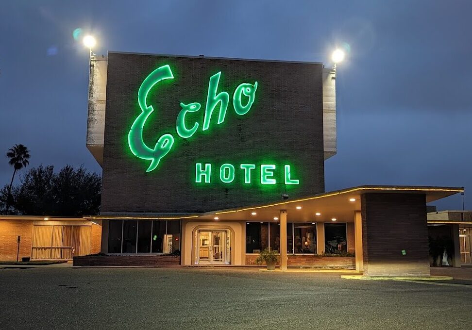 Green Echo Hotel neon sign at night