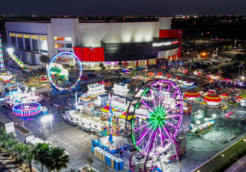 Nighttime aerial carnival with neon Ferris wheel