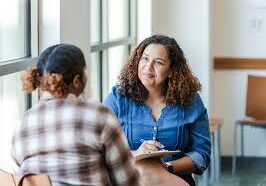 Therapist speaking with client near window