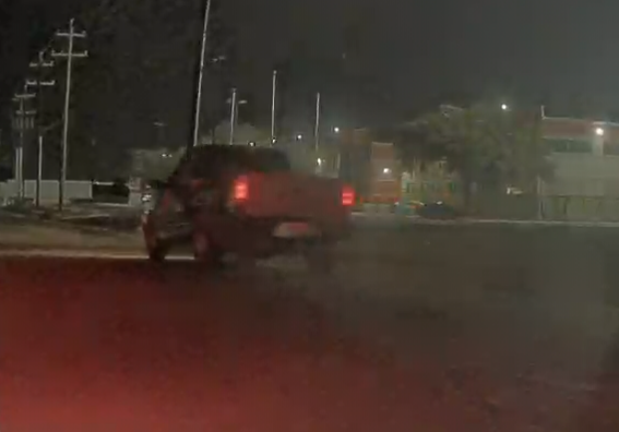 Pickup truck driving on wet road at night