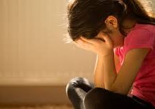 Upset girl sitting with hands over face