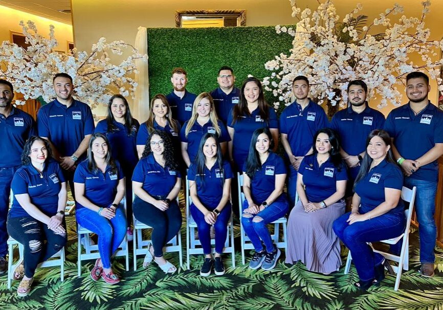 Group of smiling adults in matching blue shirts