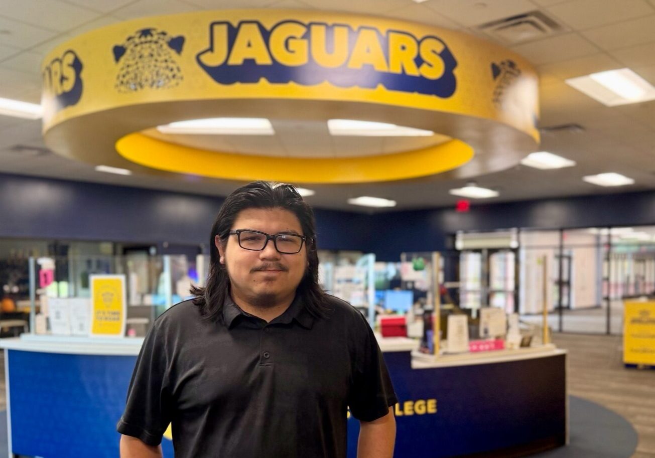 Person in college lobby under Jaguars sign