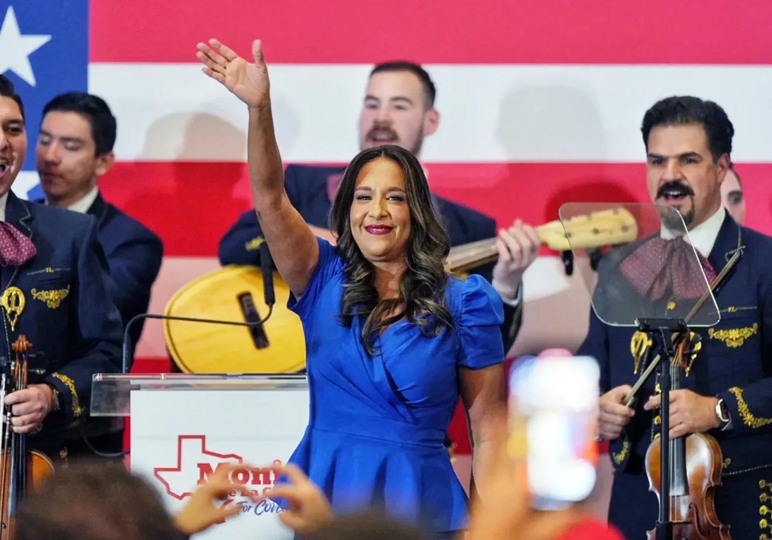 Woman waving on stage with mariachi band