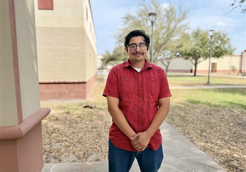 Young man in red shirt standing outdoors
