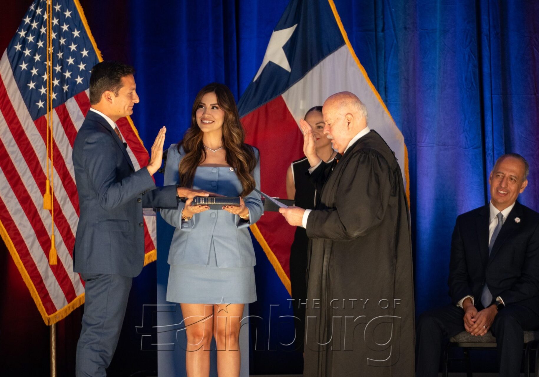 Person taking oath under U.S. and Texas flags