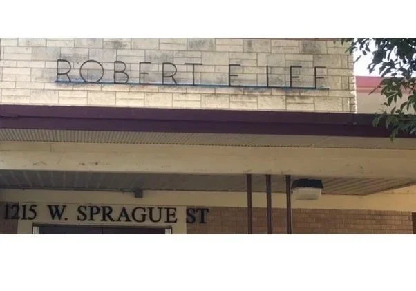 Stone facade with metal-lettered sign and address