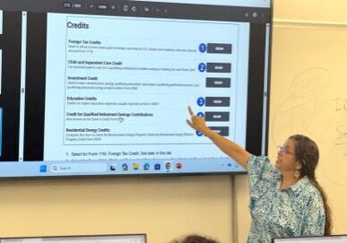 Instructor pointing at projected credits list