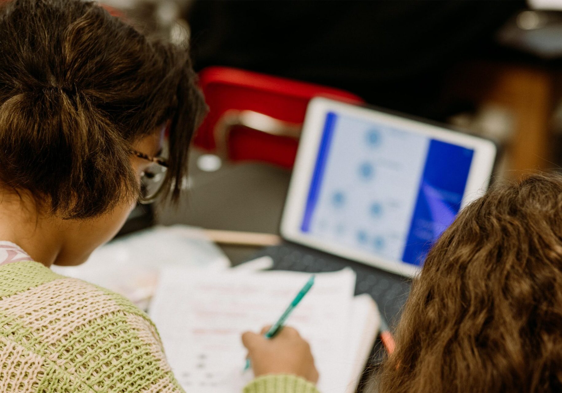 Two students studying with tablet and papers