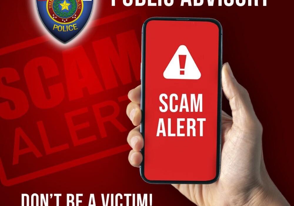 Hand holding phone displaying scam alert