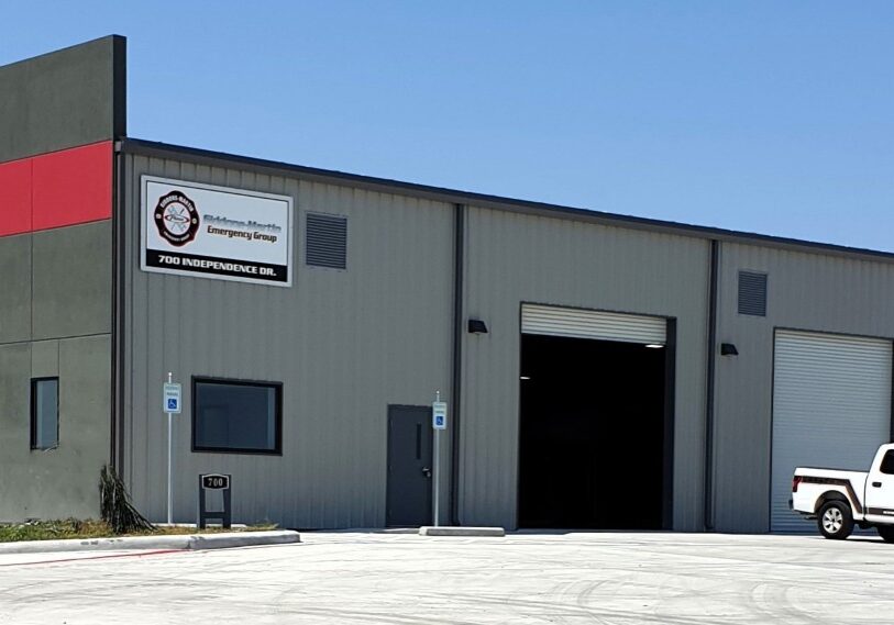 Gray industrial warehouse with white pickup truck