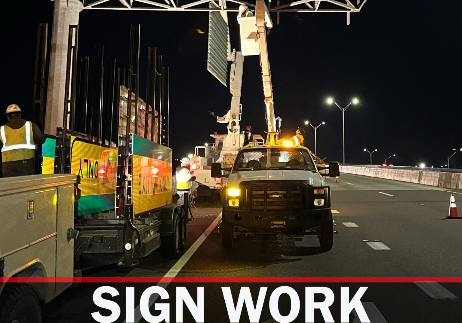 Texas DOT workers installing highway sign at night