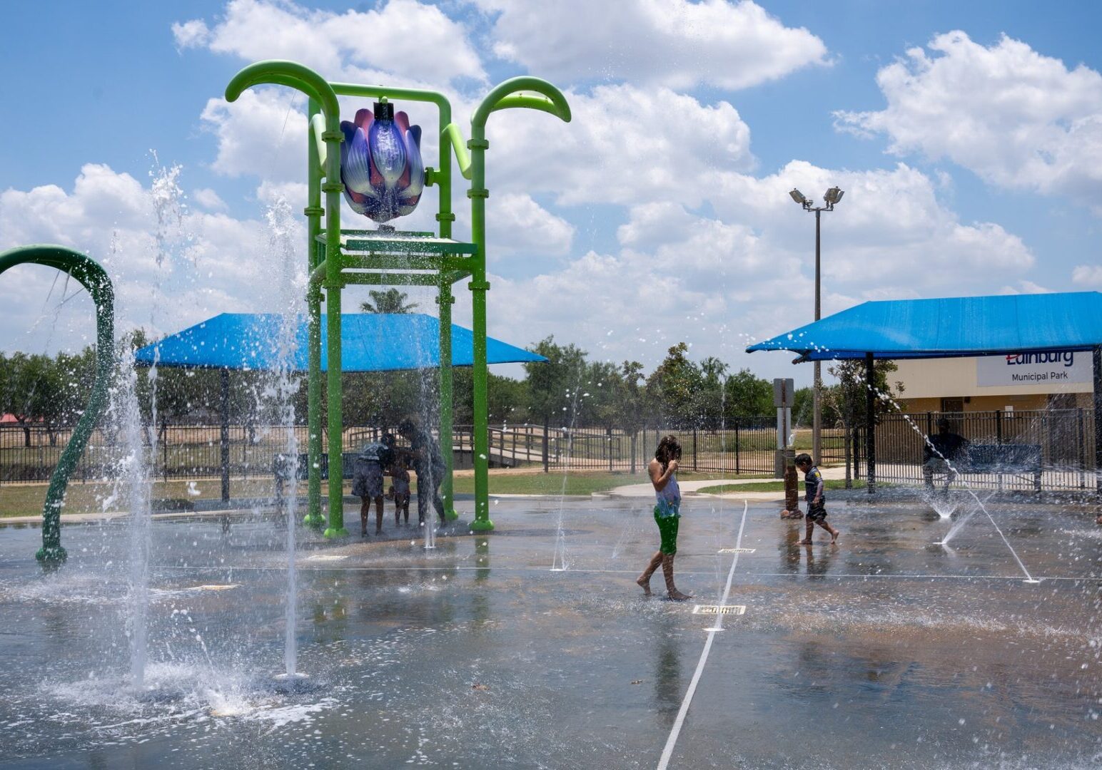 Children playing at outdoor splash pad fountains