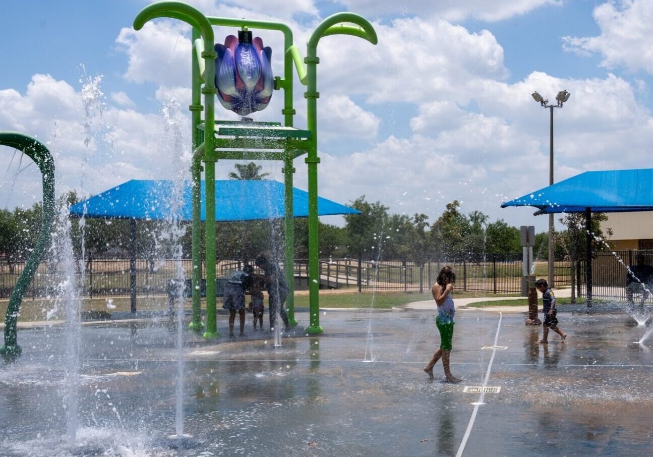 Children playing at park splash pad fountains
