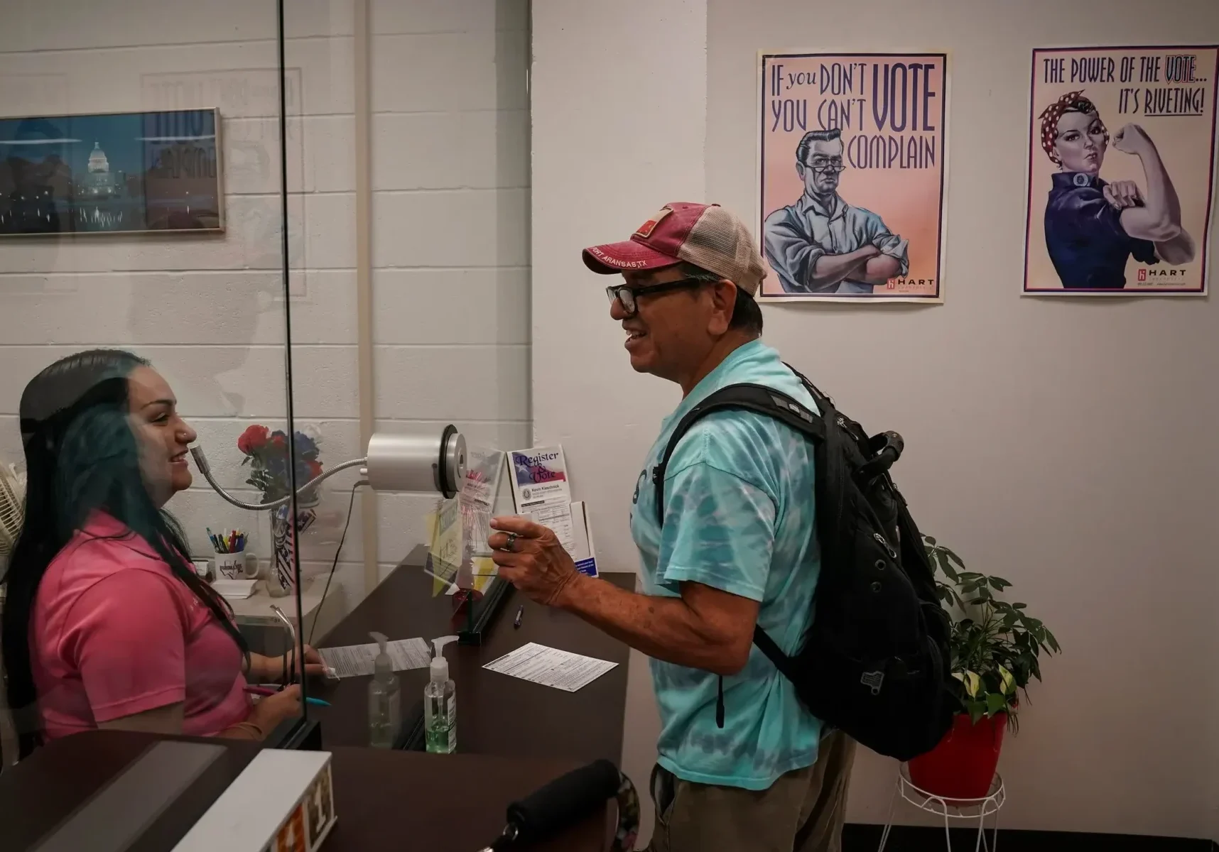 Man speaking to receptionist through plexiglass