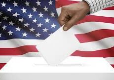 Hand placing ballot into box with American flag