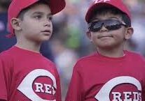 Two boys in red Reds baseball jerseys