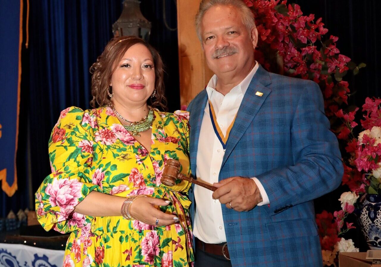 Woman in floral dress and man holding gavel