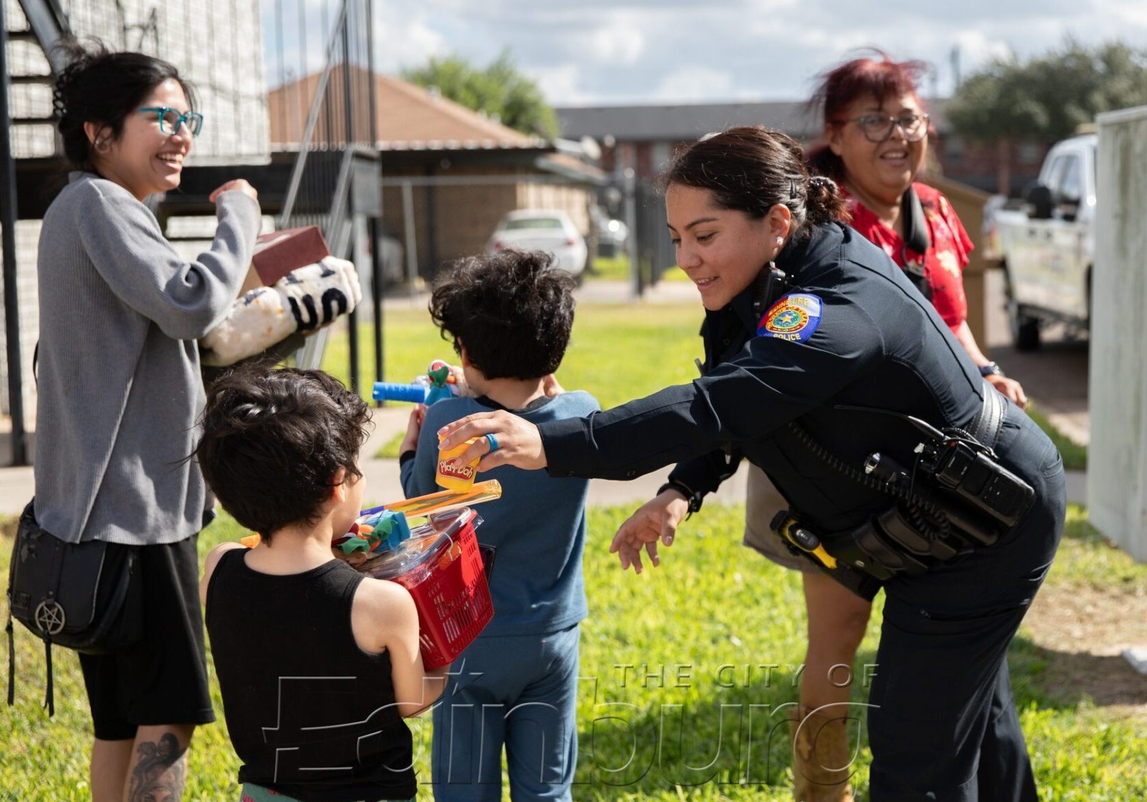 Police officer handing toys to smiling children
